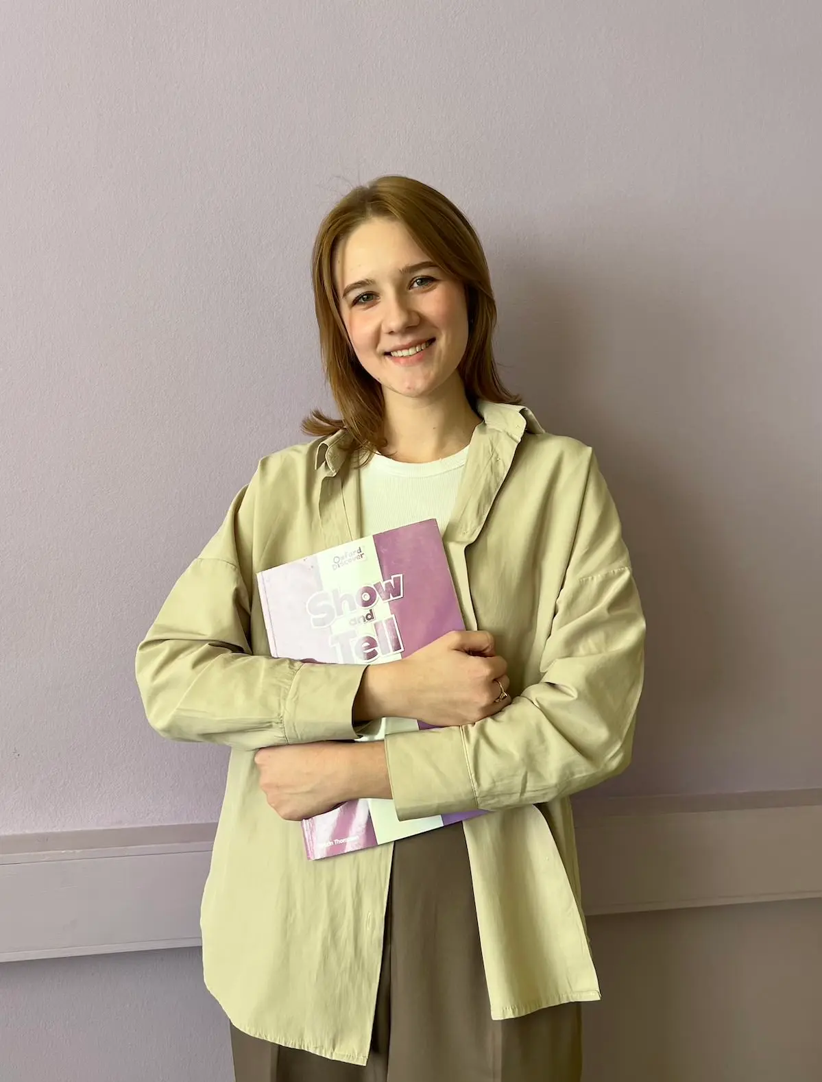Улыбающаяся преподавательница школы Eager Beaver с учебником.