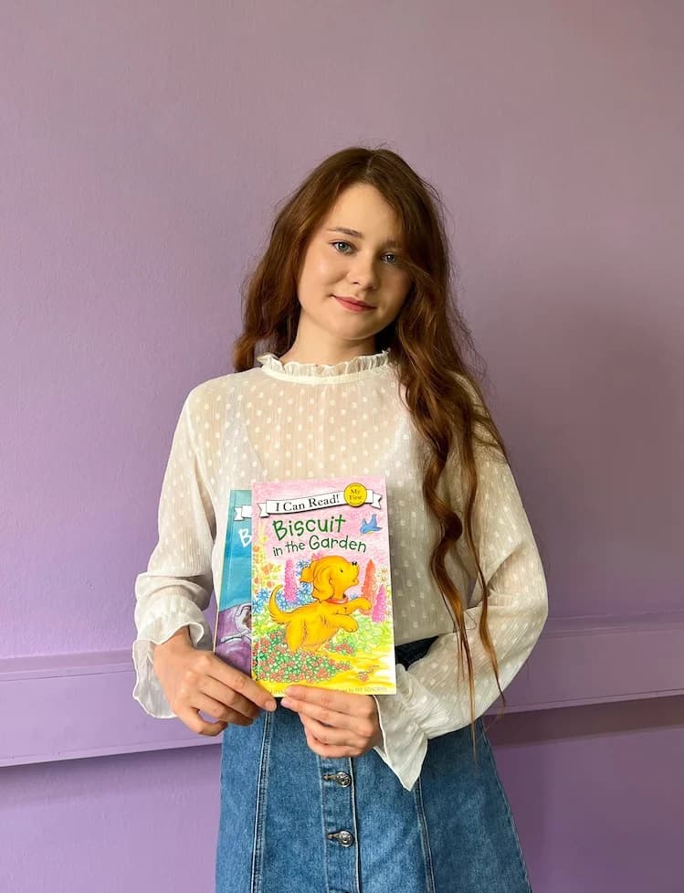 Преподаватель школы Eager Beaver с детскими книгами на английском.